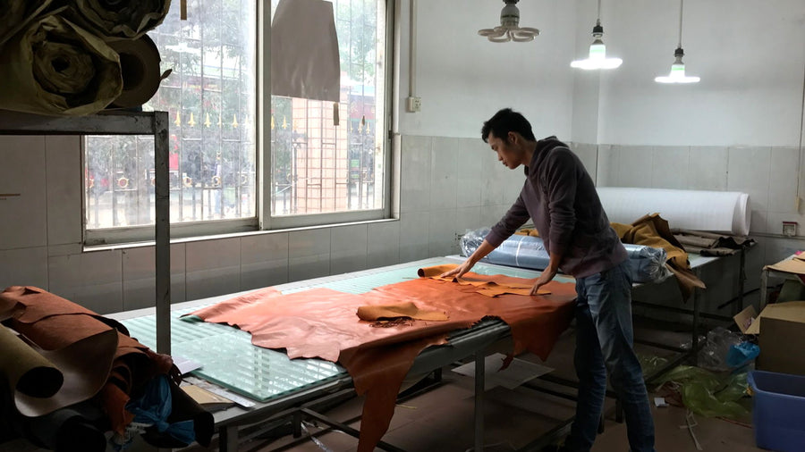 Aarons Leather team member inspecting a leather hide before cutting