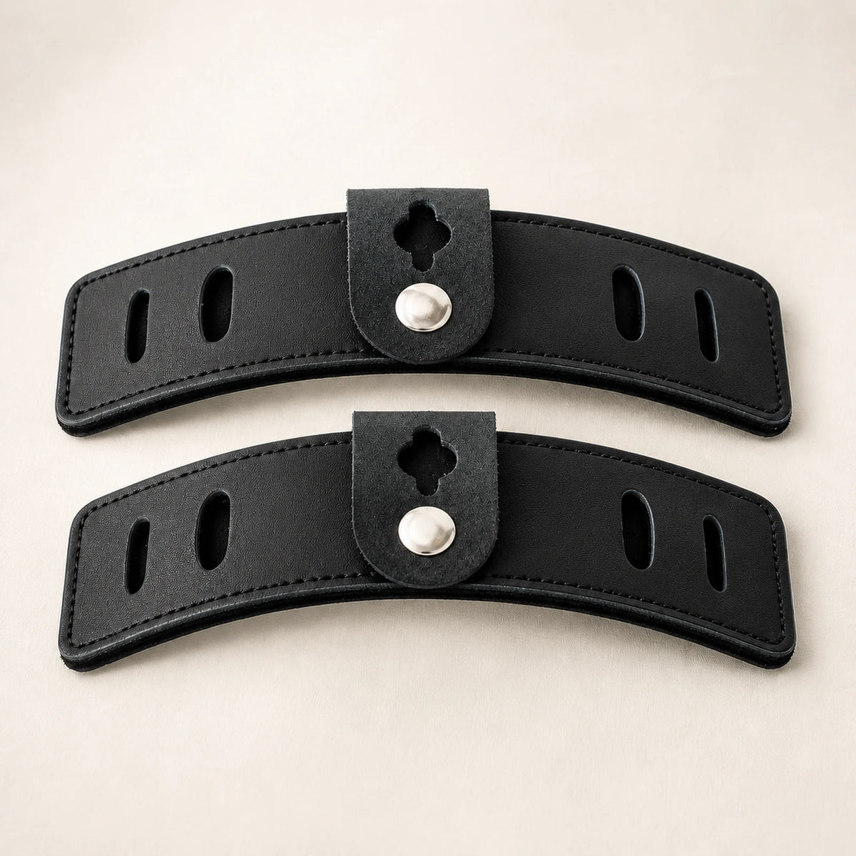 Close-up of curved leather equestrian guards with slots and snap tabs