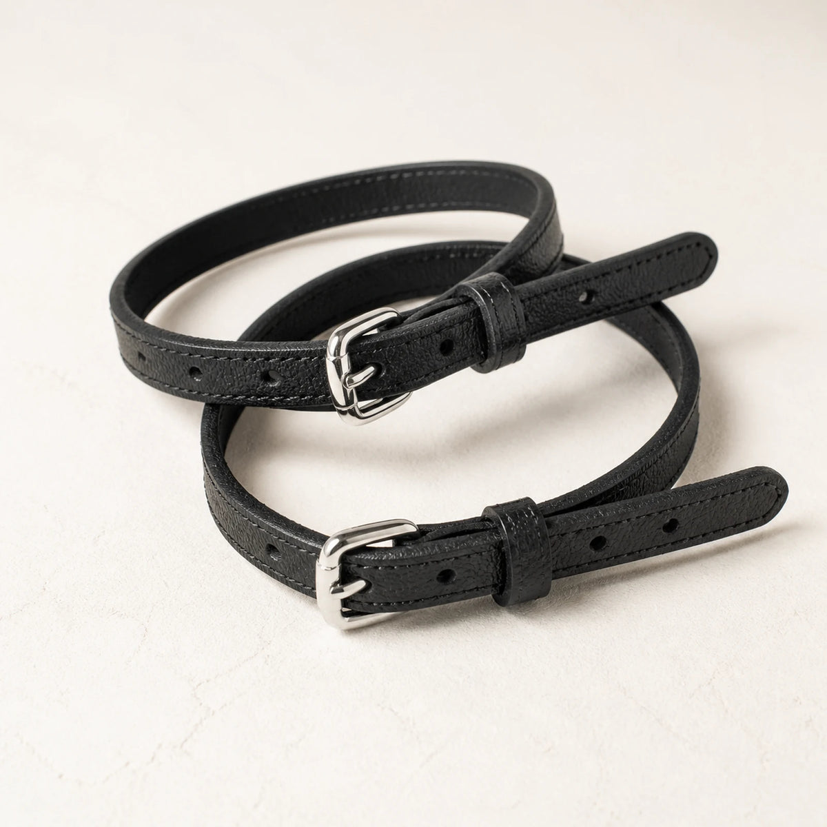 Close-up of adjustable black leather straps and silver buckles