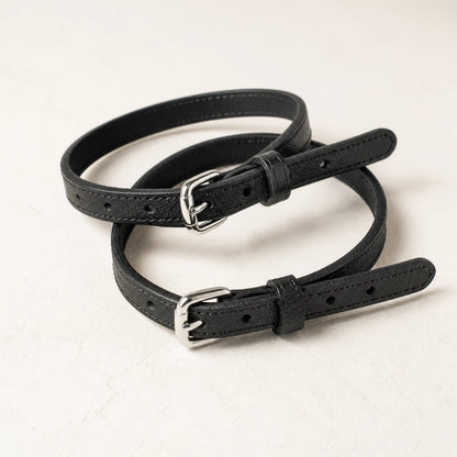 Close-up of adjustable black leather straps and silver buckles