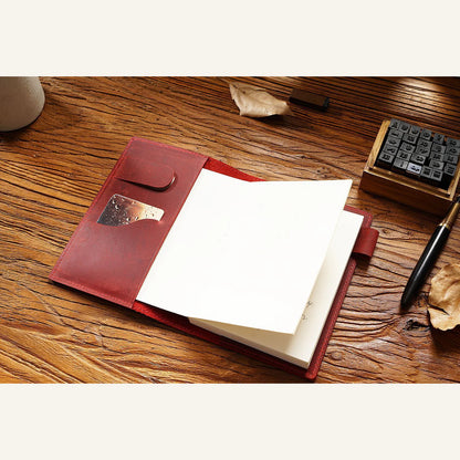 Open leather notebook cover showing refill sleeves, organizer pocket and pen loop