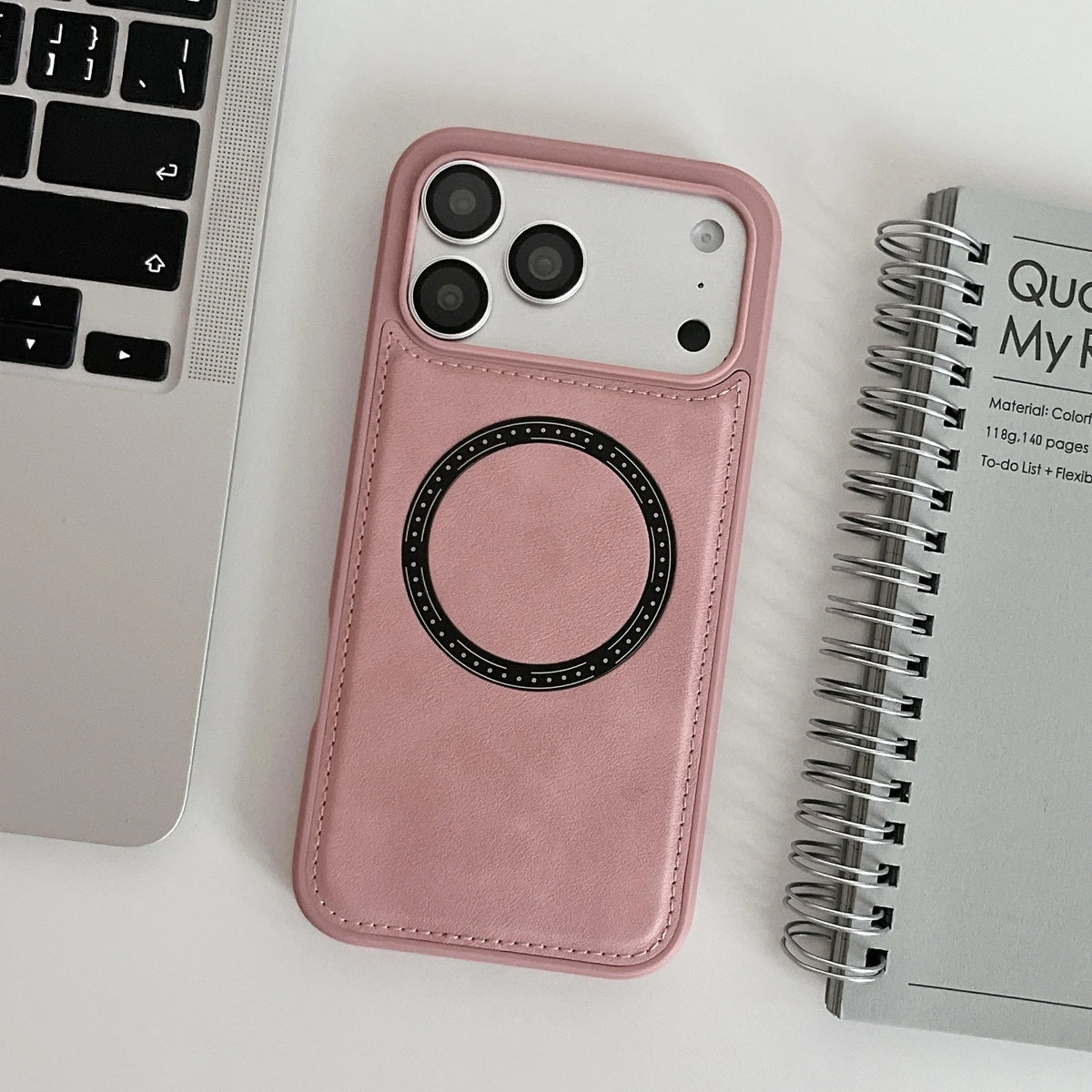 Pink stitched imitation leather ring phone case, shown beside computer and notebook props; props not included