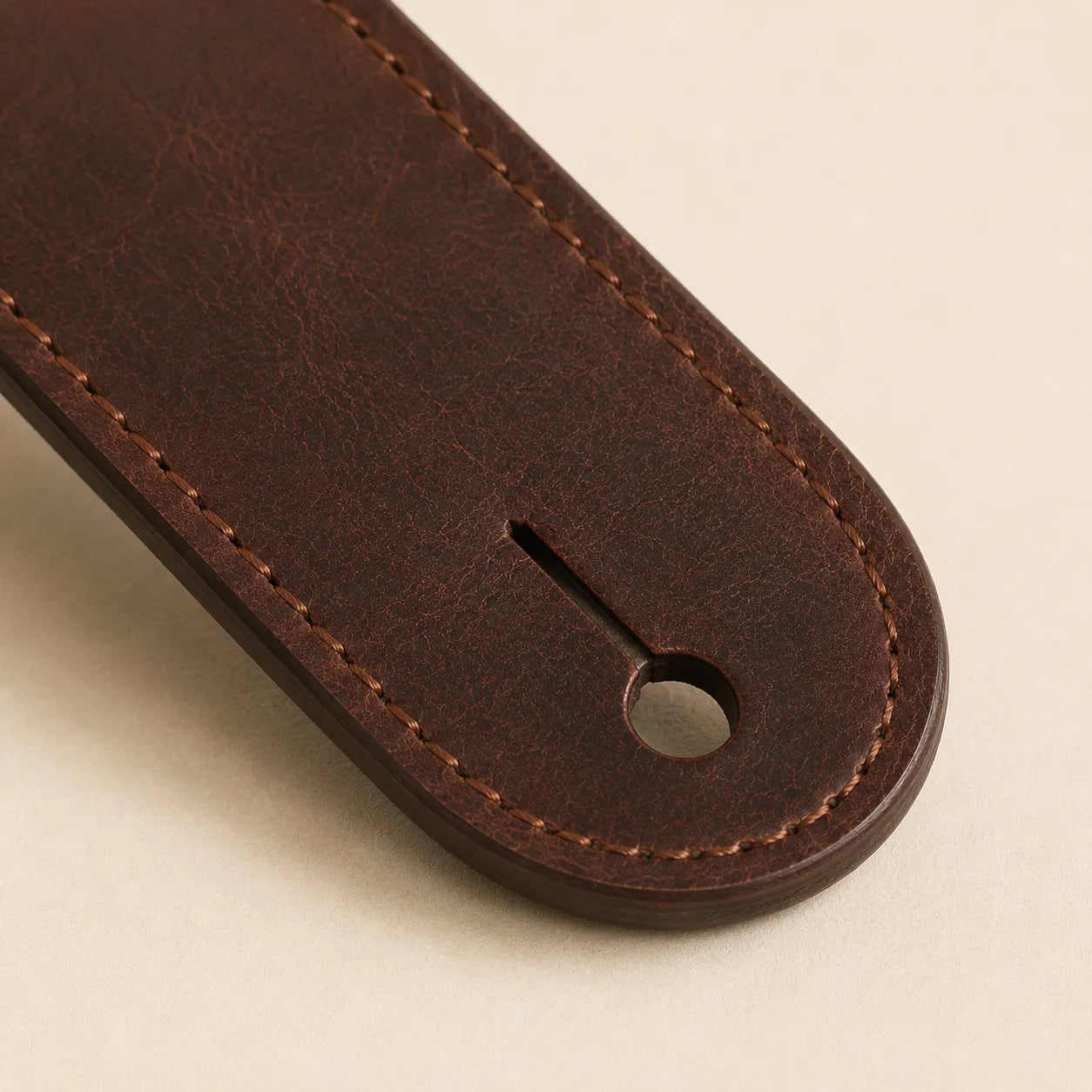 Close-up of guitar strap end slot and full-grain leather edge finishing