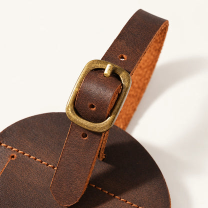 Antique-brass-tone pin buckle detail on the arched luggage tag detachable leather strap