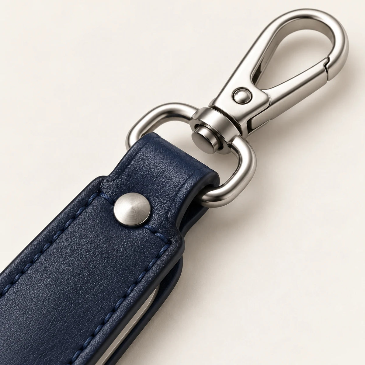 Close-up of navy leather loop, rivet, D-ring and swivel spring clip
