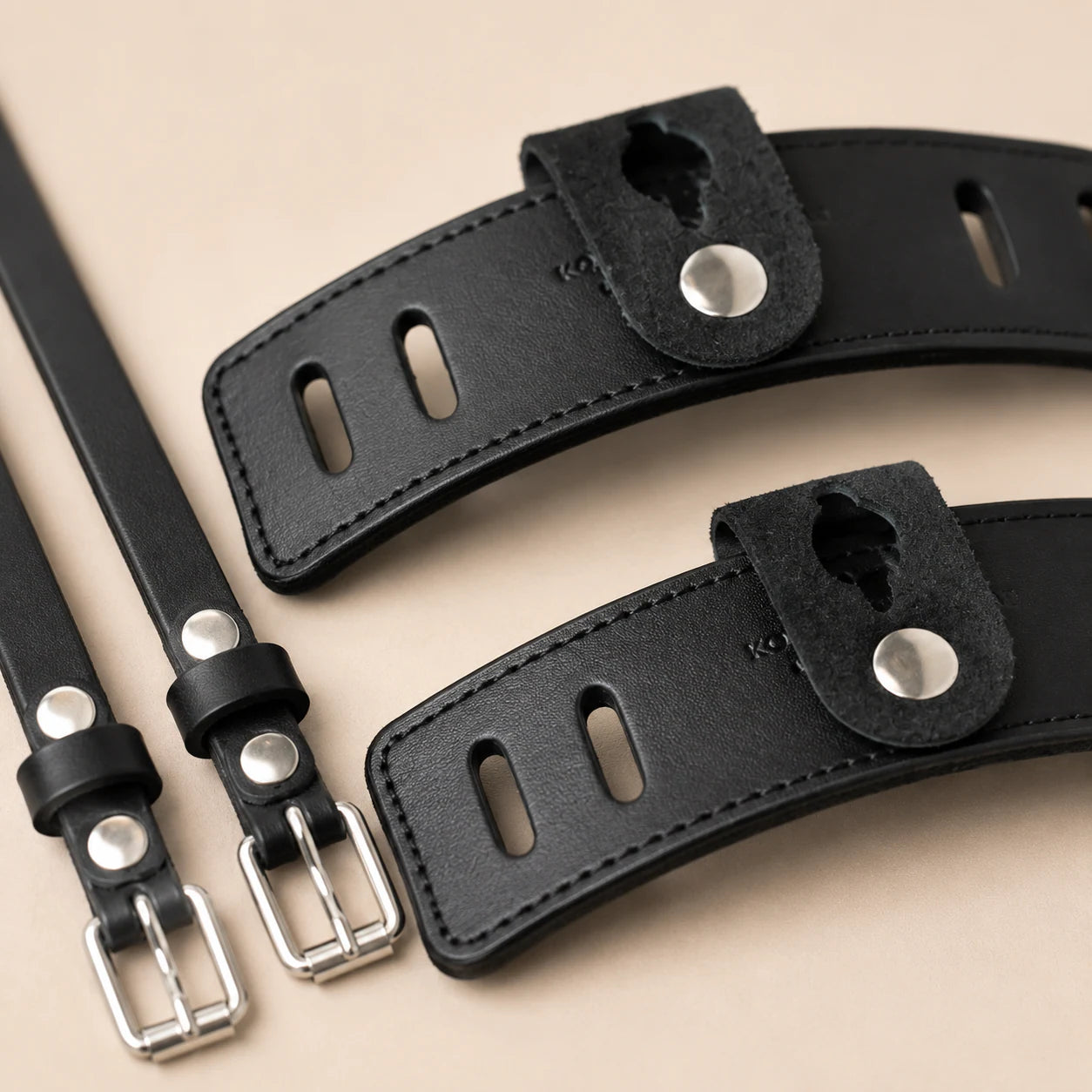 Close-up of leather spur guard slots snap tab and metal buckles