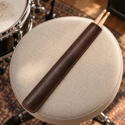 Leather drumstick sleeve in a music setting; sticks and instruments are not included