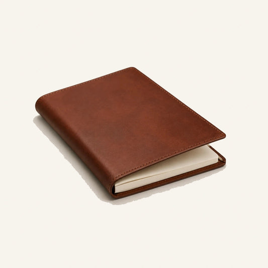 Angled view of custom leather journal notebook with blank cream paper insert