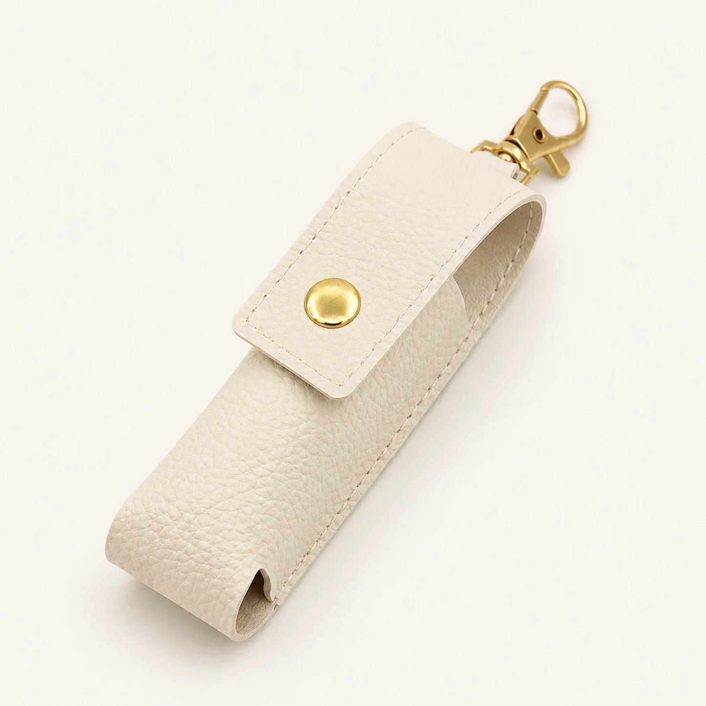 Ivory portable lipstick holder keychain with snap flap and gold-tone swivel clasp, front view