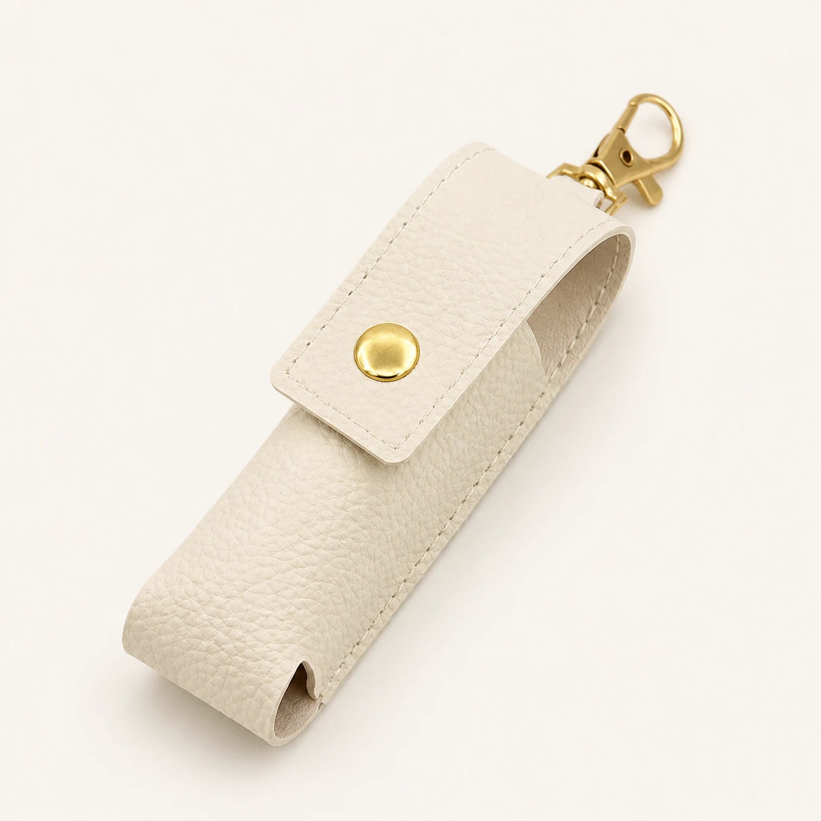 Ivory portable lipstick holder keychain with snap flap and gold-tone swivel clasp, front view