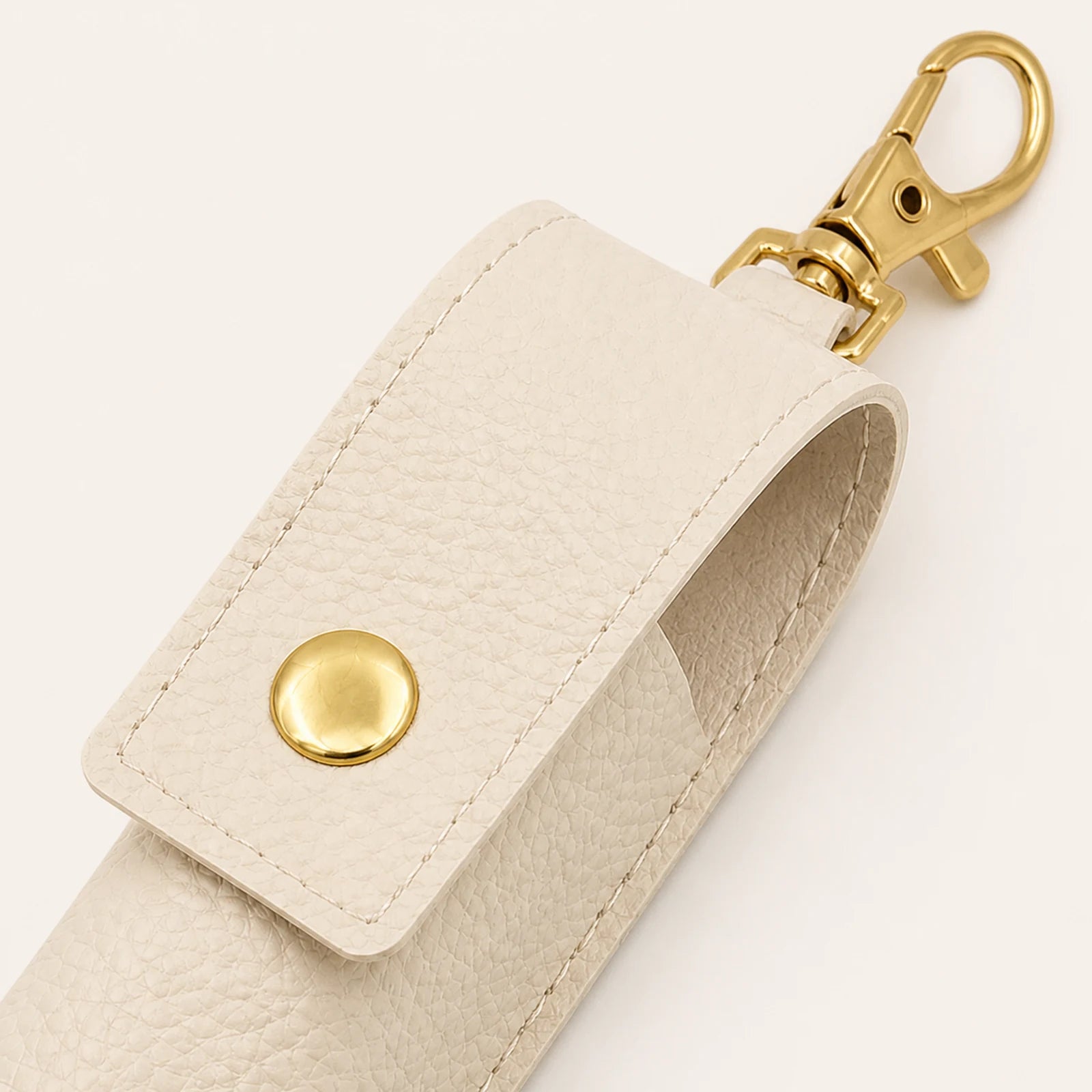 Close-up of the round snap closure and gold-tone swivel lobster clasp