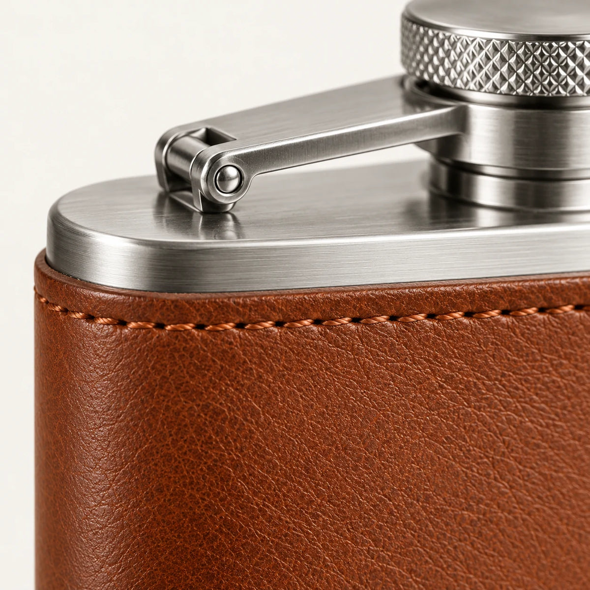 Close-up of leather stitching and captive cap assembly on the hip flask design