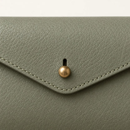 Close-up of the stud-and-slot closure, leather grain and stitching
