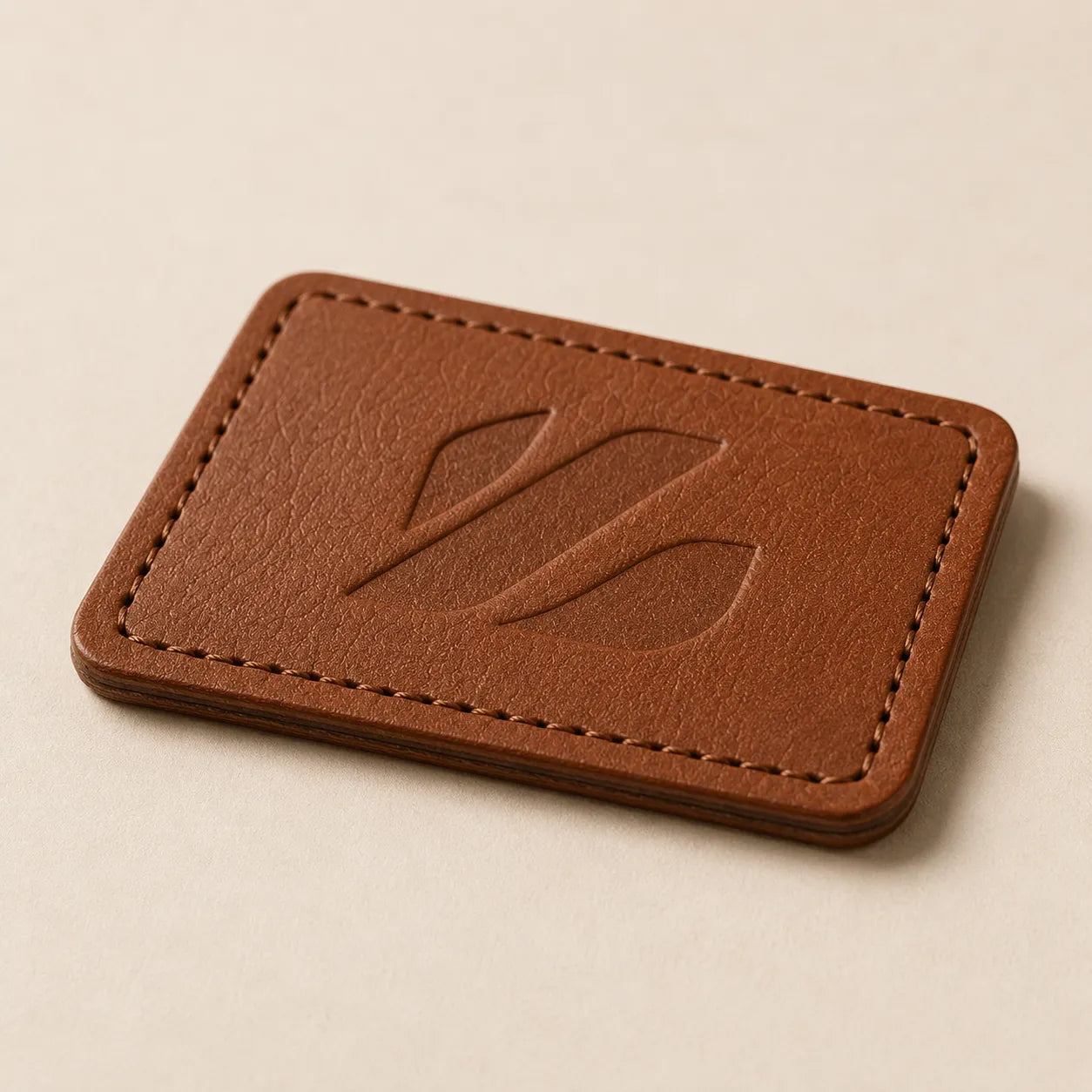 Angled view of debossed leather hat patch with laser-cut edge