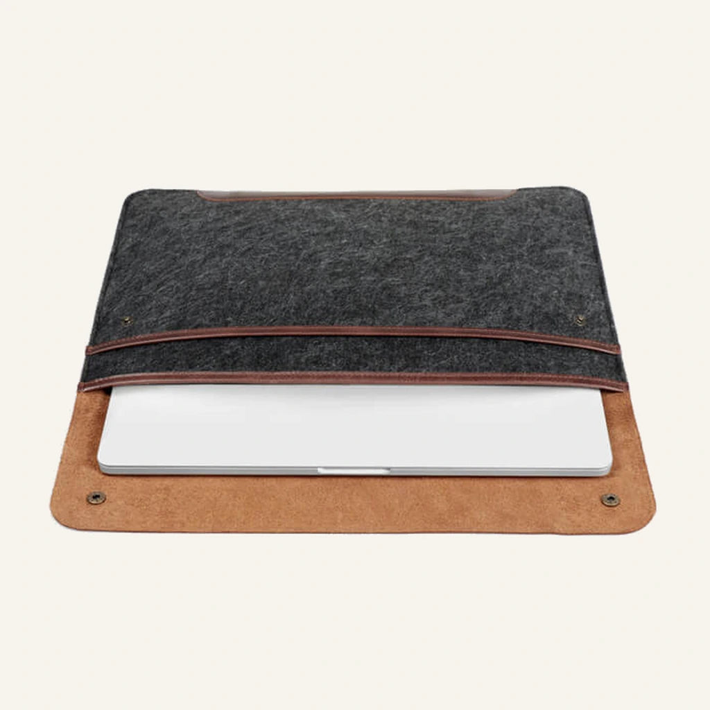 Gray felt and brown leather laptop sleeve open with a laptop inside