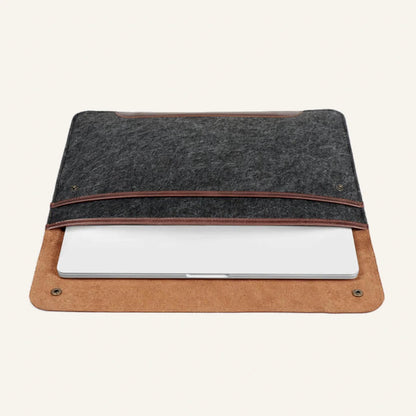 Gray felt and brown leather laptop sleeve open with a laptop inside