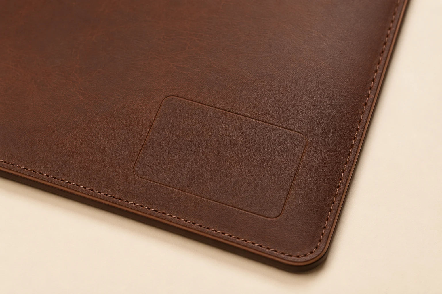 Blank logo customization area on leather desk mat with cable slot
