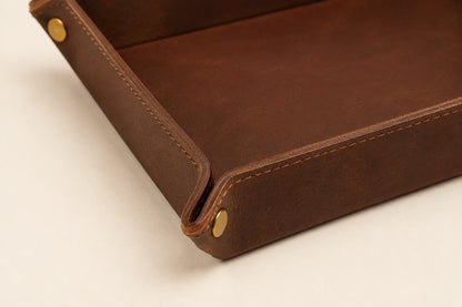 Close-up of leather tray corner snap hardware stitching and edge finishing