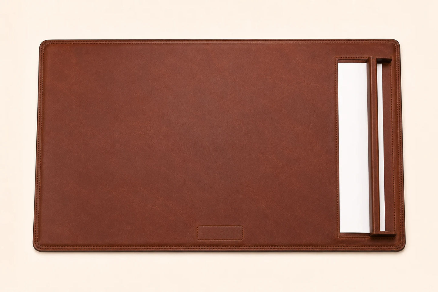 Top-down view of leather desk pad with side paper rail and blank paper sheet
