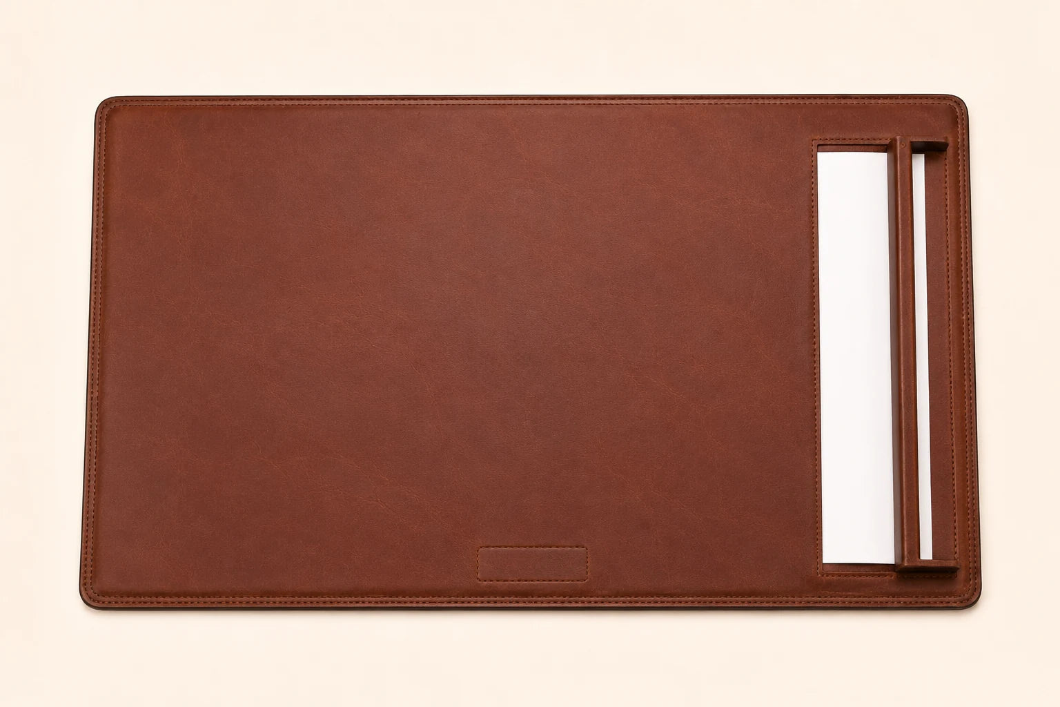 Top-down view of leather desk pad with side paper rail and blank paper sheet