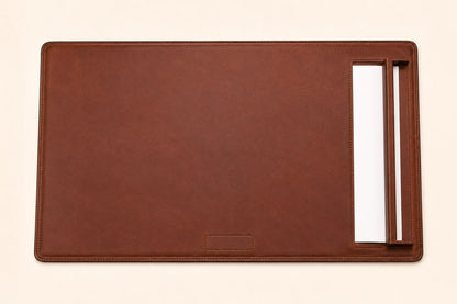 Top-down view of leather desk pad with side paper rail and blank paper sheet