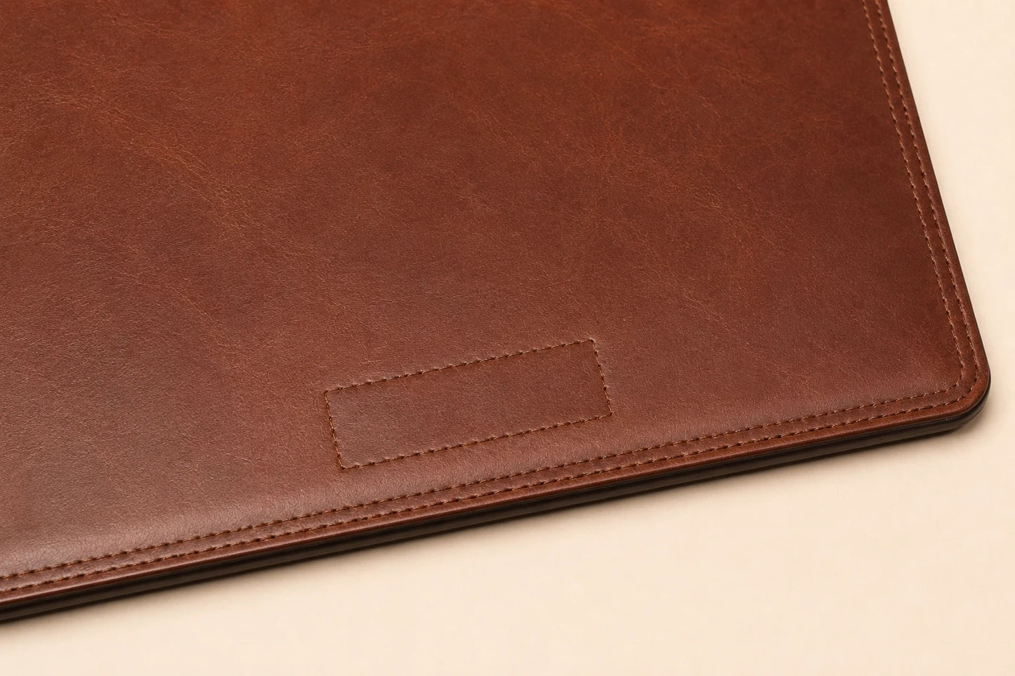 Blank logo debossing area on leather desk pad with stitched border