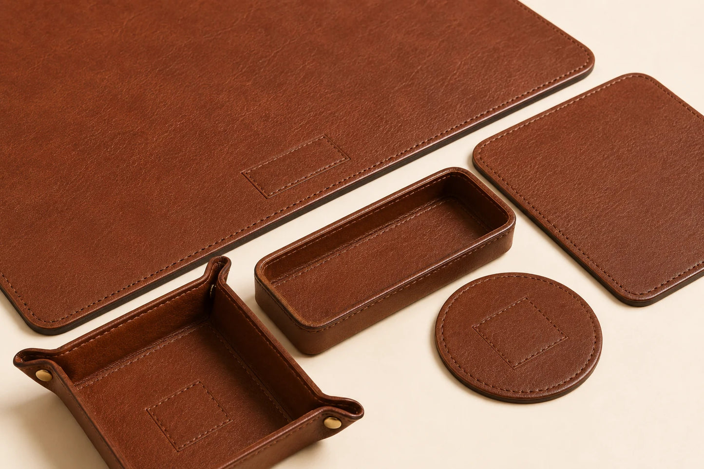 Close-up of matching leather stitching and edge finishing across office desk set pieces