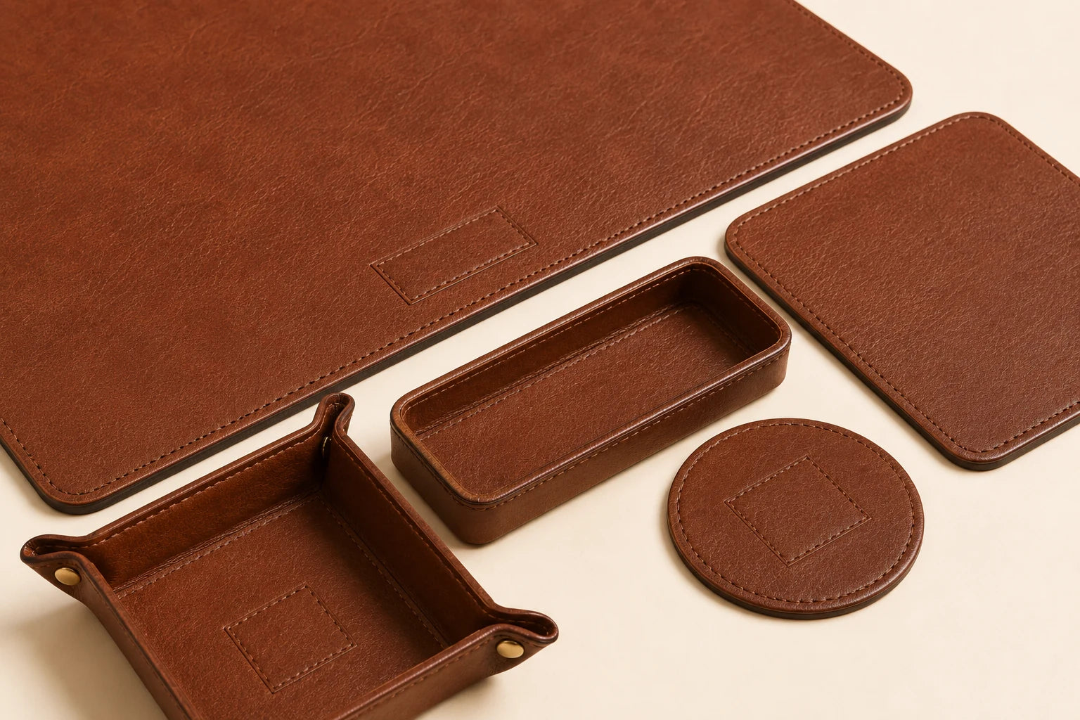 Close-up of matching leather stitching and edge finishing across office desk set pieces