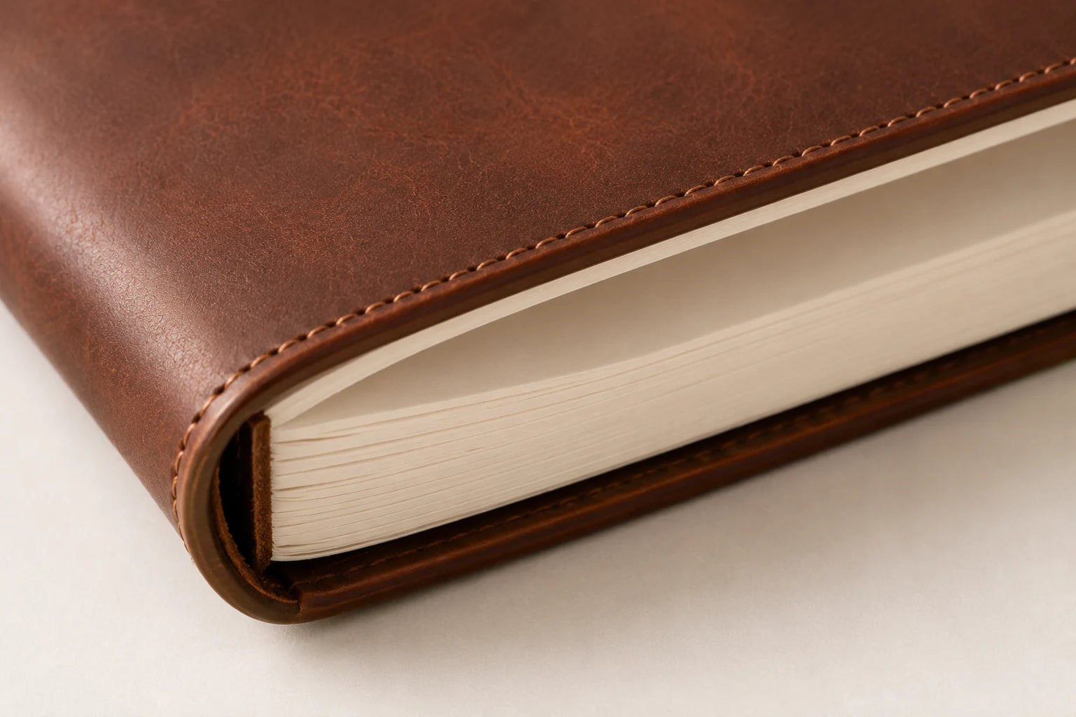 Close-up of thick blank sketchbook paper insert and leather cover edge