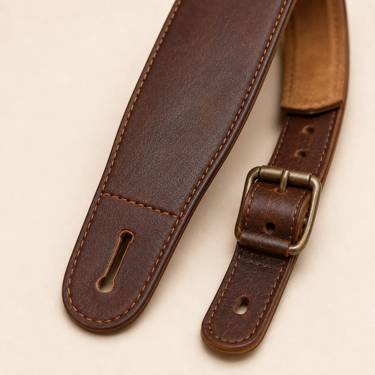 Strap end slot stitching and edge finishing detail on padded guitar strap