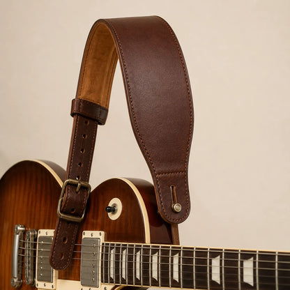 Padded brown leather guitar strap attached to guitar concept sample