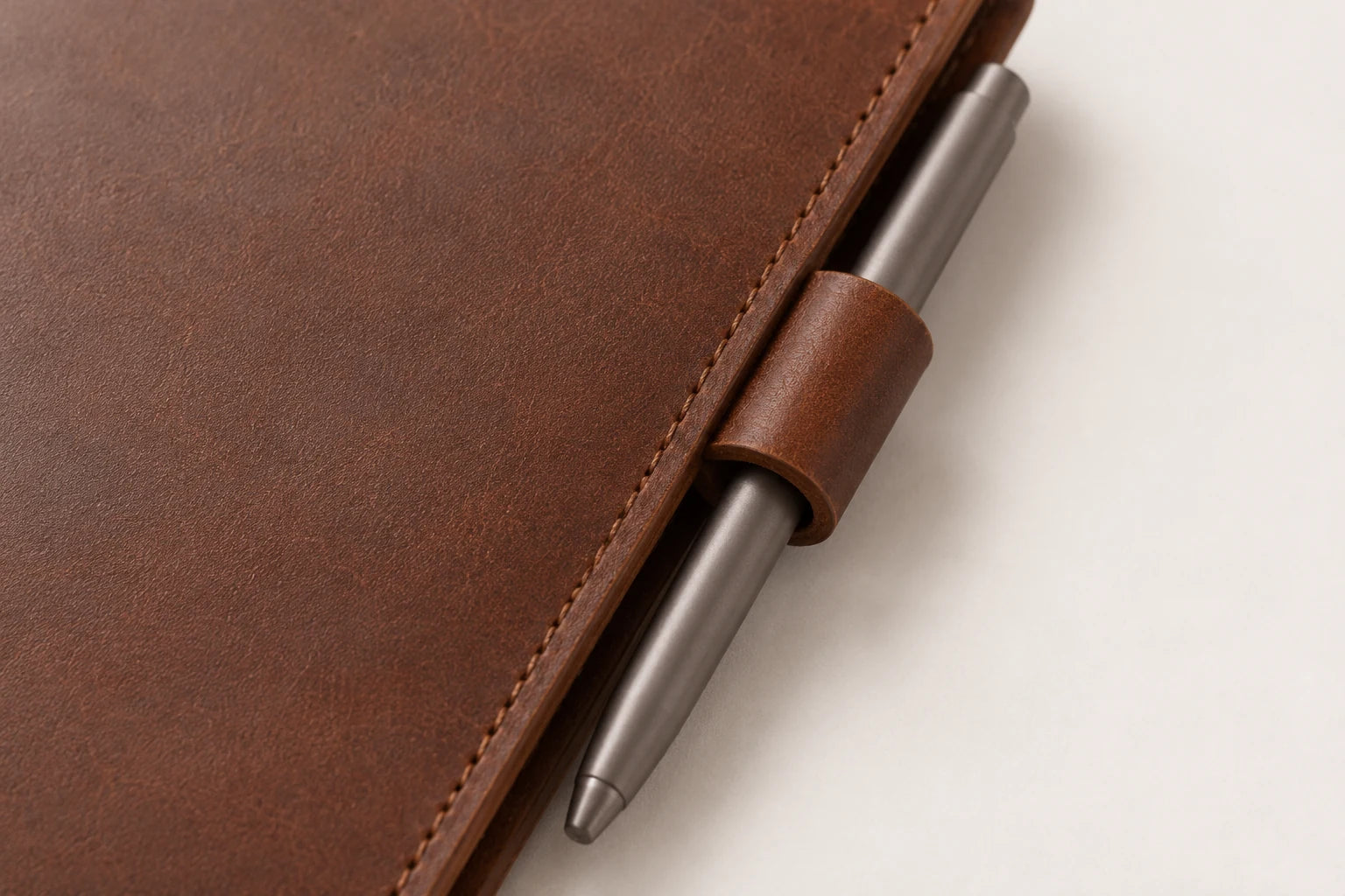 Close-up of stitched leather pen loop on personalized notebook cover