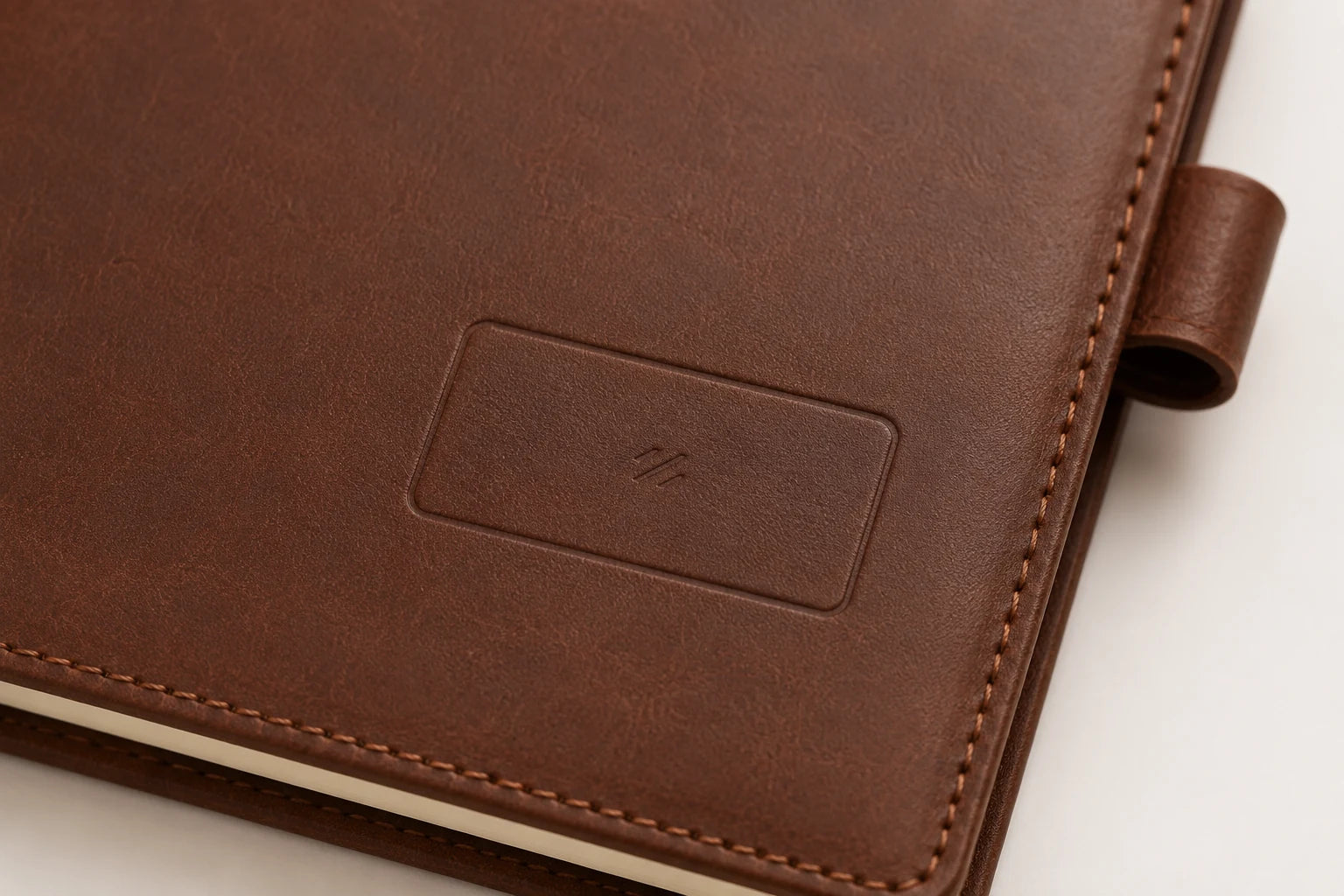 Blank logo debossing area on brown leather notebook cover